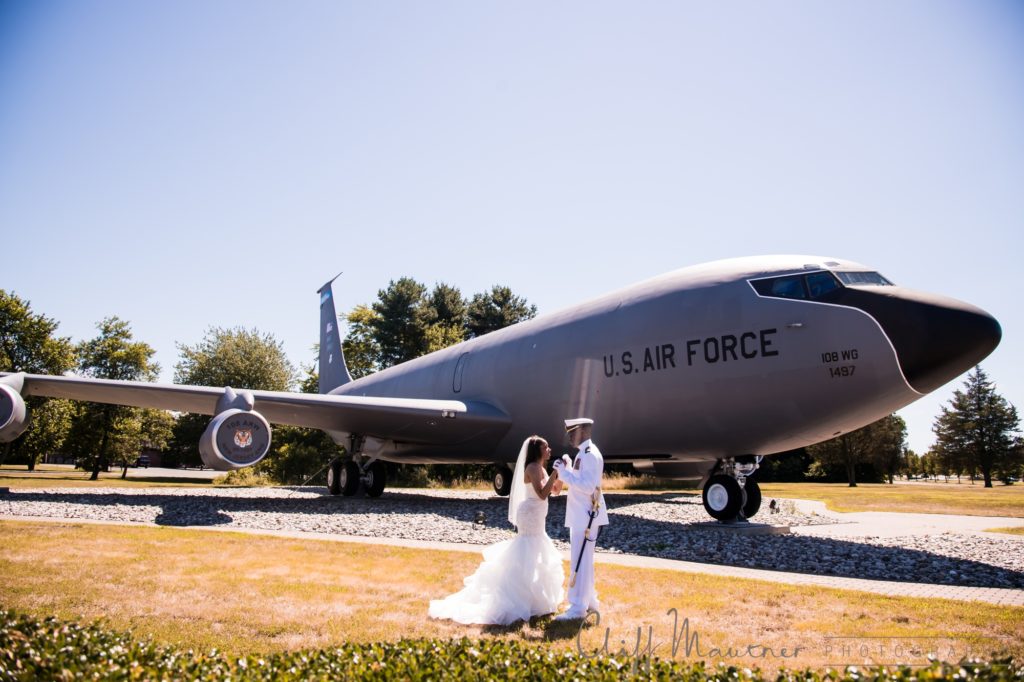 Bride and groom on their wedding day at Fort Dix, New Jersey with a United States Air Force plane in the background.